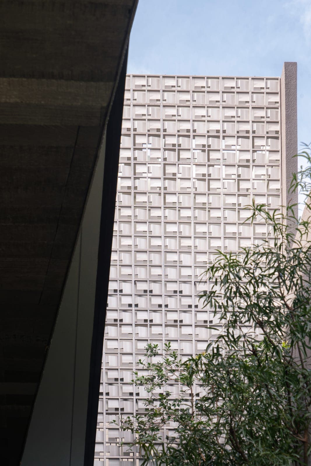 The breeze-block wall, under a canted concrete soffit.