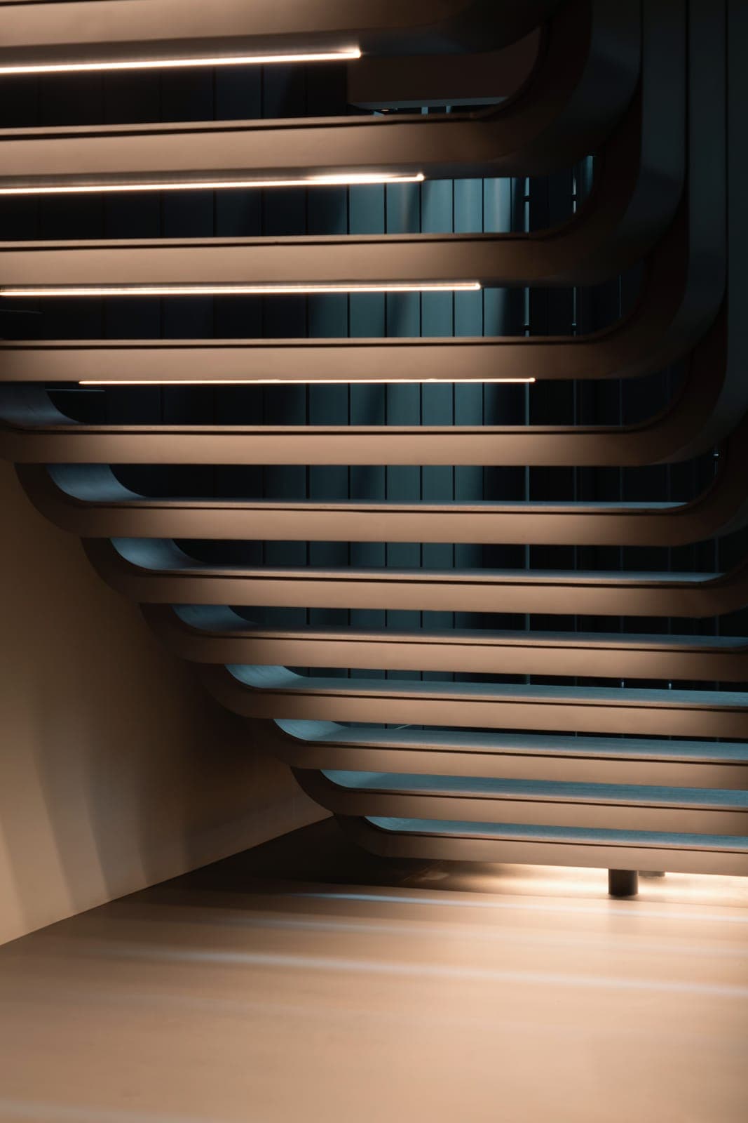 The stair from below, each tread lit along its underside.