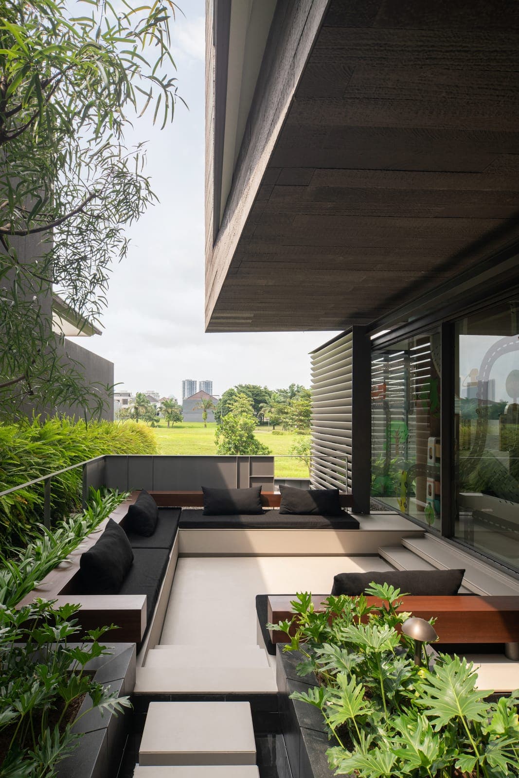The terrace under its overhang, field beyond.