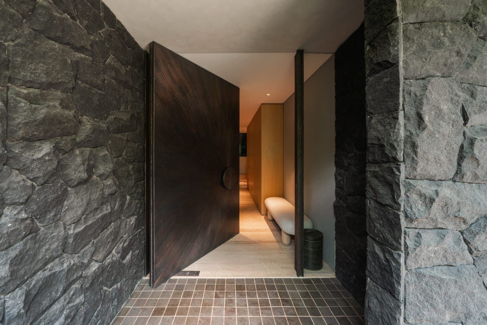 The entrance: a timber pivot between two walls of cleft stone.