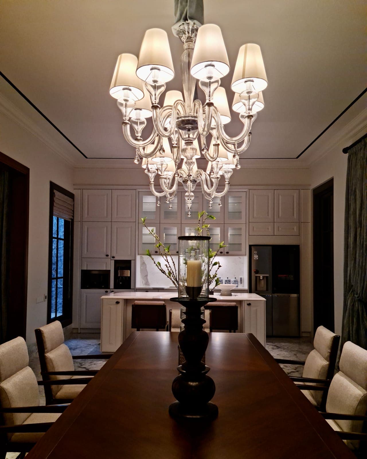 The chandelier, and the panelled room under it.