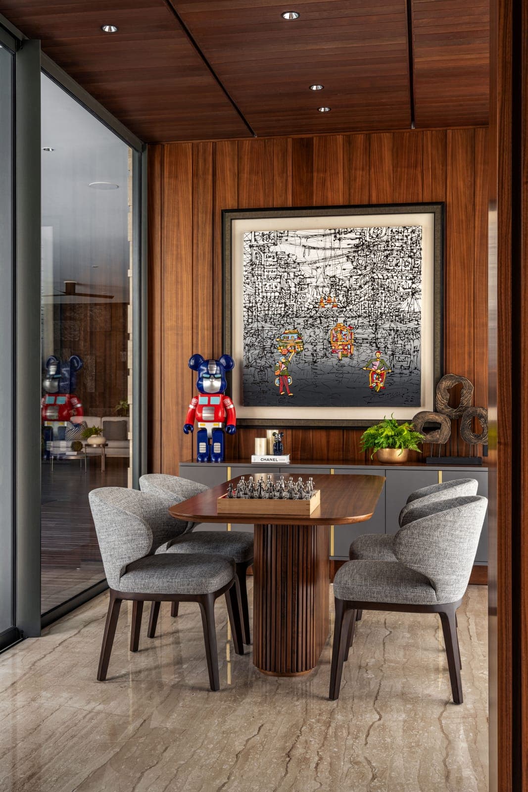 The dining room, a darker box hung with art.