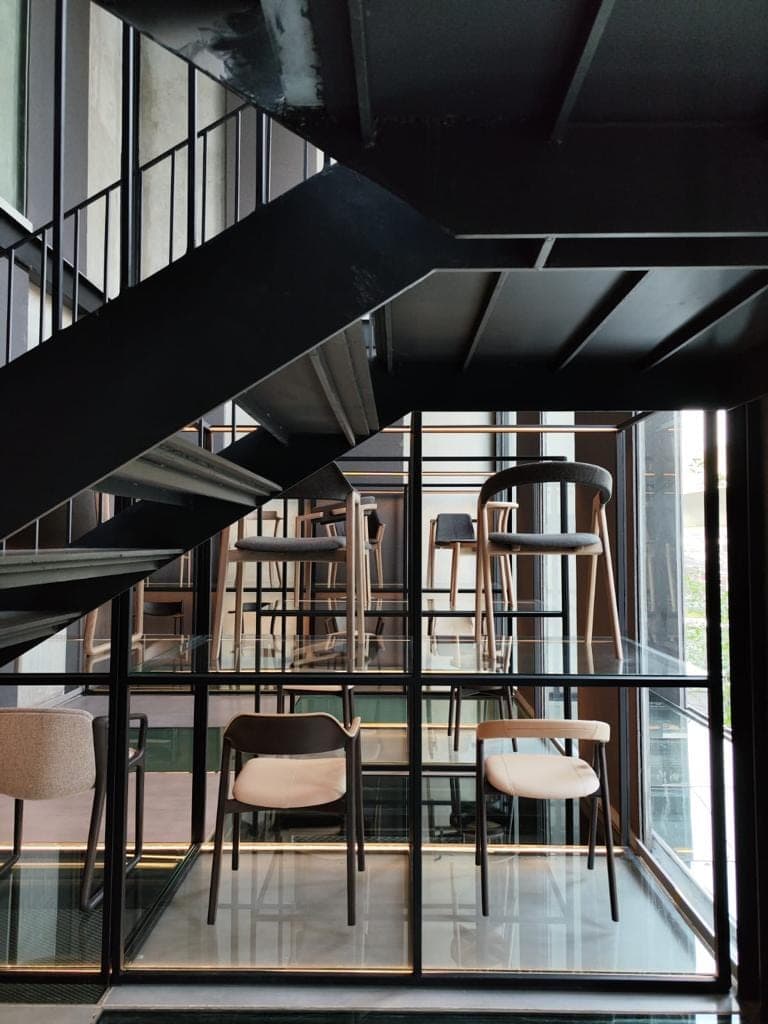 A glazed room standing inside the steel grid.