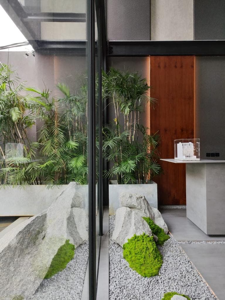 The court — stone, moss and bamboo behind full-height glazing.