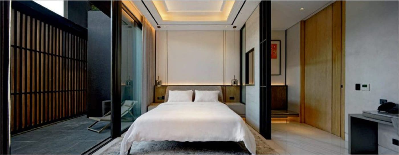 In the principal bedroom, a TECHNAL Topaze slider opens to a quiet, timber-screened court.
