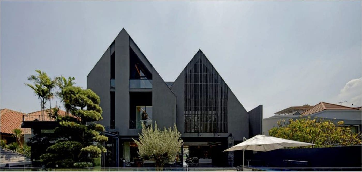 The garden elevation — twin gables above the pool and the open living level.