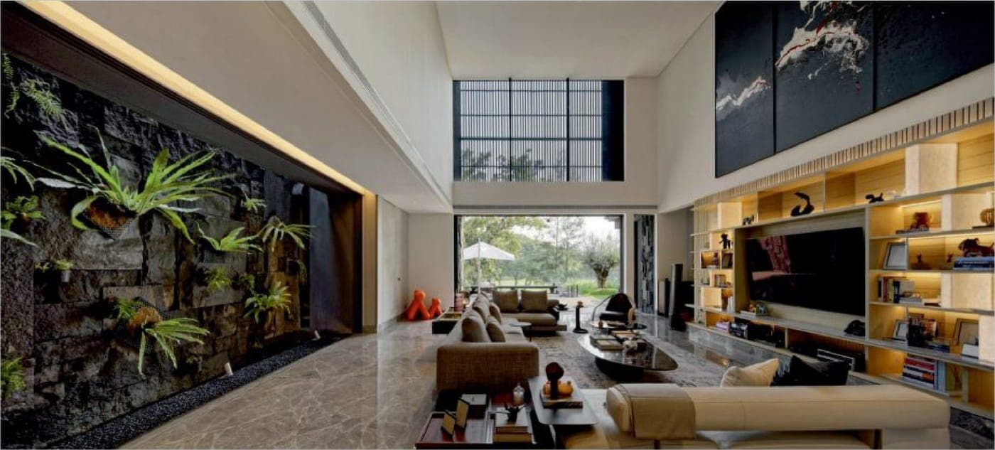 The double-height living room opens to the garden on FREMO Invisi sliding — the sill clad in marble, the frame lost in the wall.