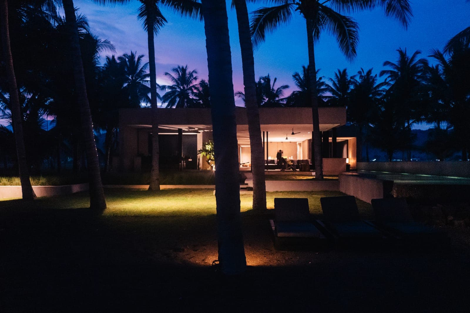 After dark, the villa among the palms.