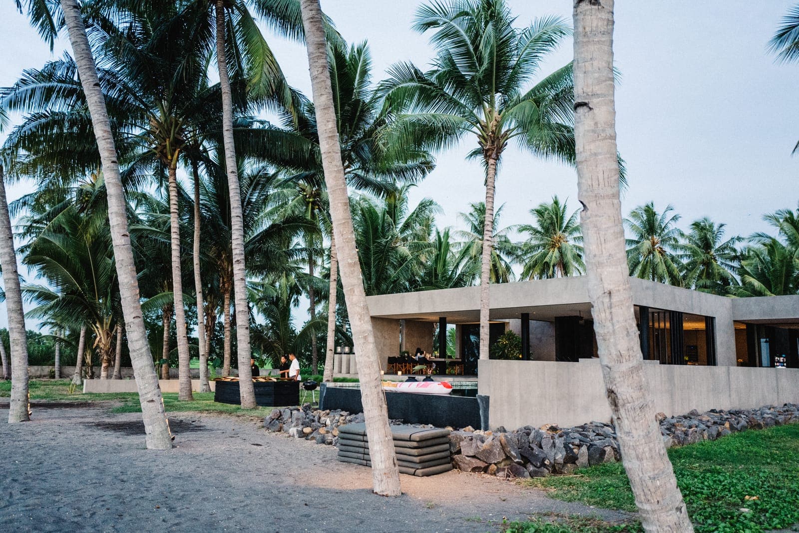 Low volumes settled among the palms, seen from the beach.