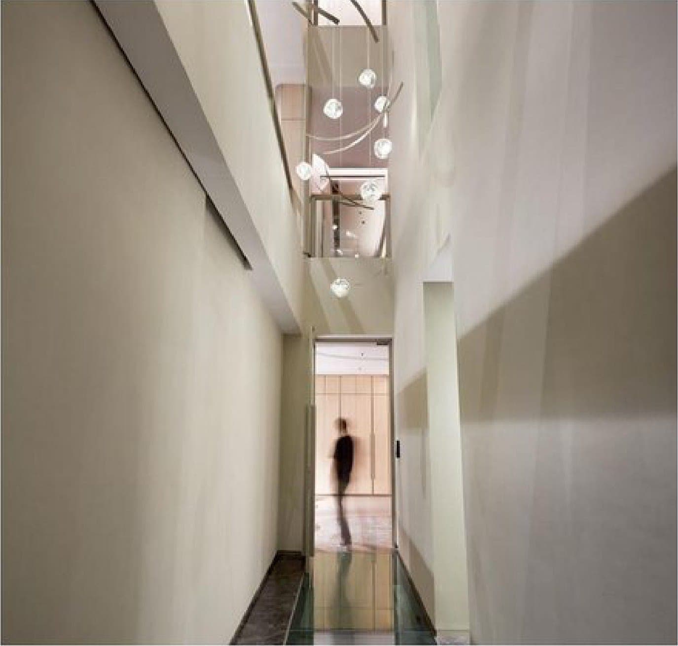 A glass bridge crosses the full-height void.
