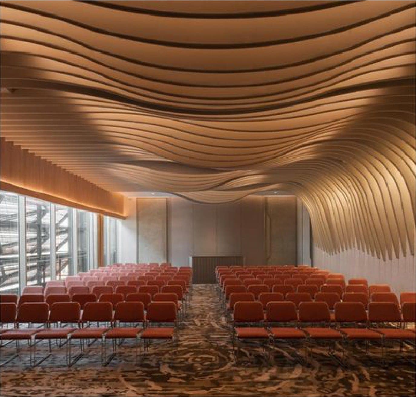 The auditorium, beneath a rippling timber ceiling.