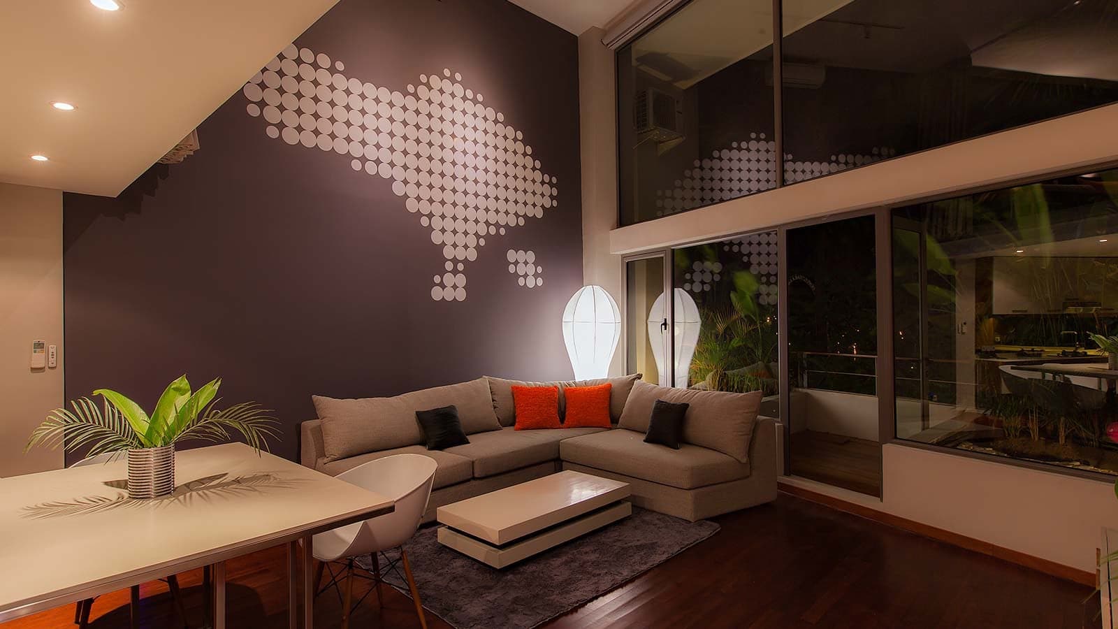 The living room at night, sliding doors onto a lit terrace.
