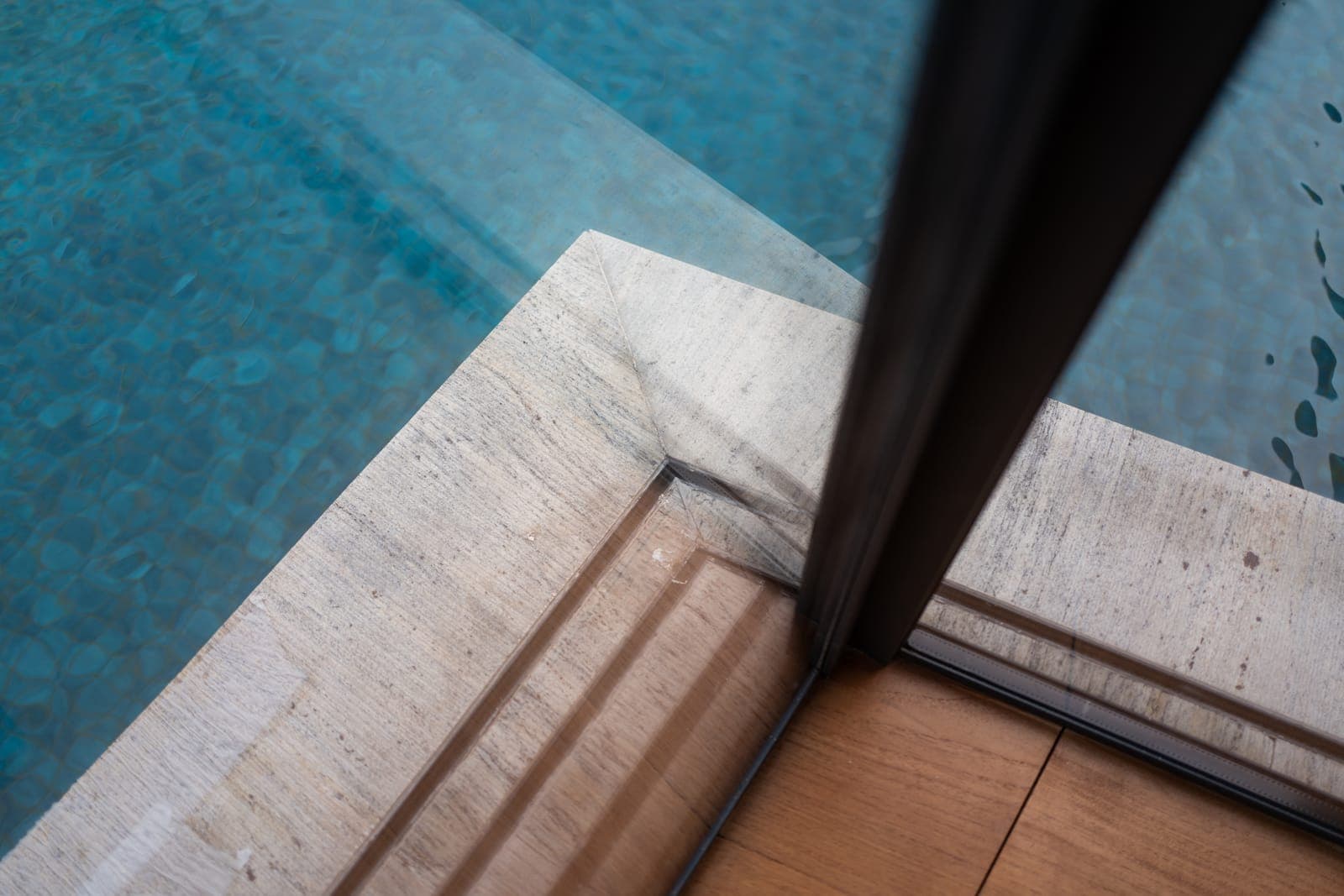 At the pool, the Fusion track meets stone over a concealed channel — the boundary reduced to a line.