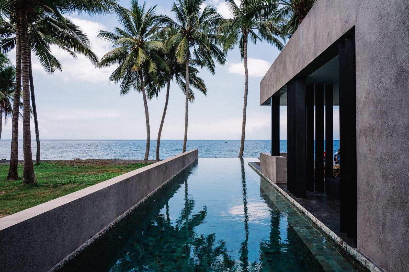 The reflecting pool runs out between the wings to the sea.