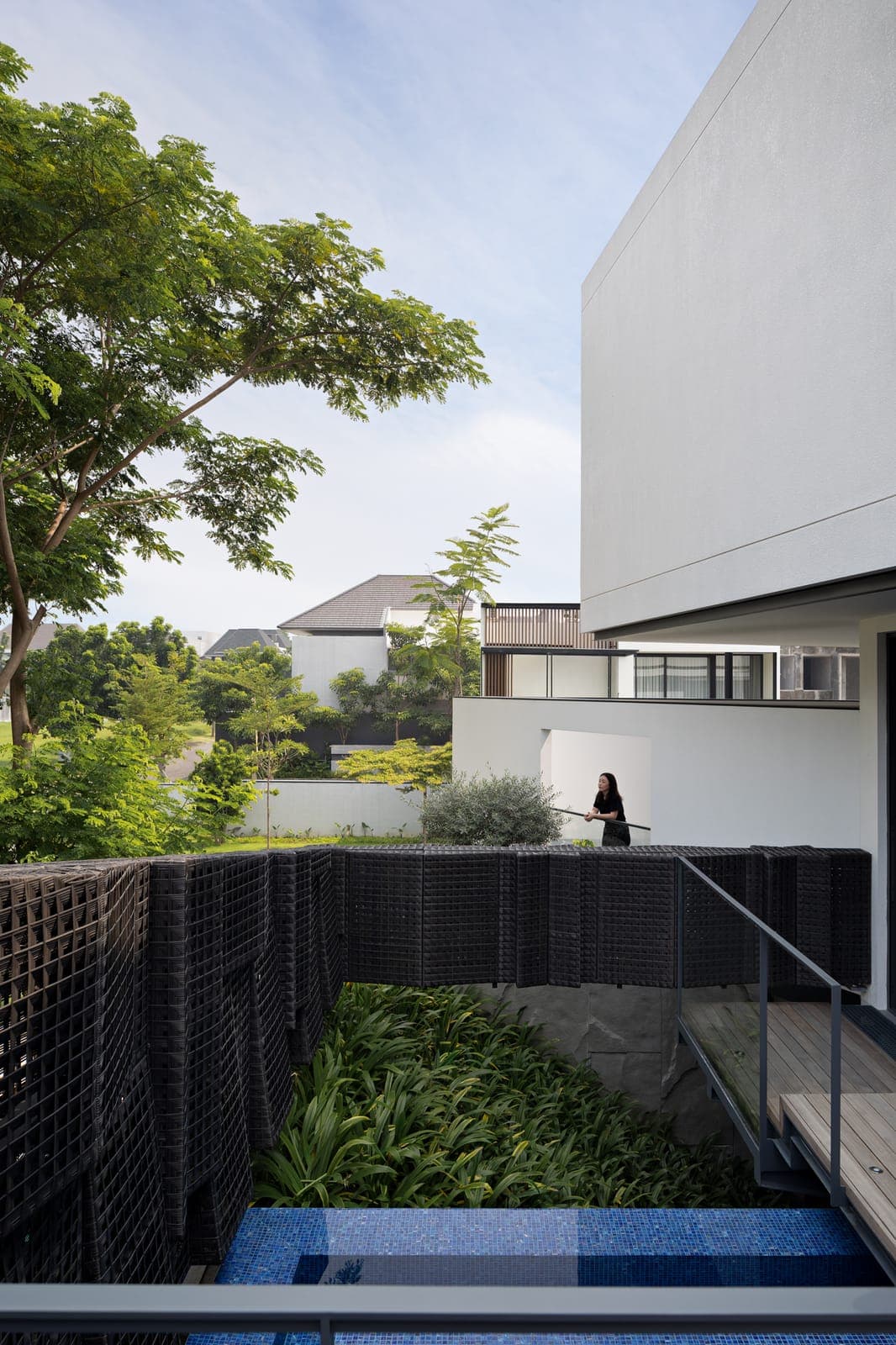 The side court above the pool, behind its folded brick screen.