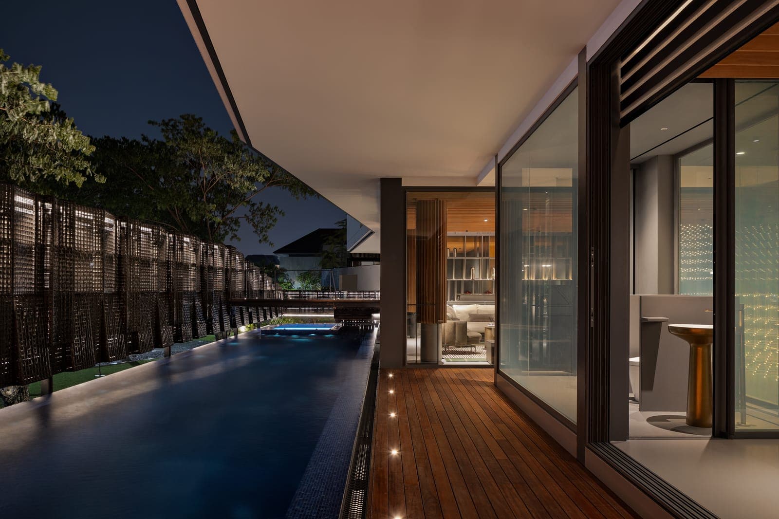 The lap pool at night, the deck brought right up to the glazing.